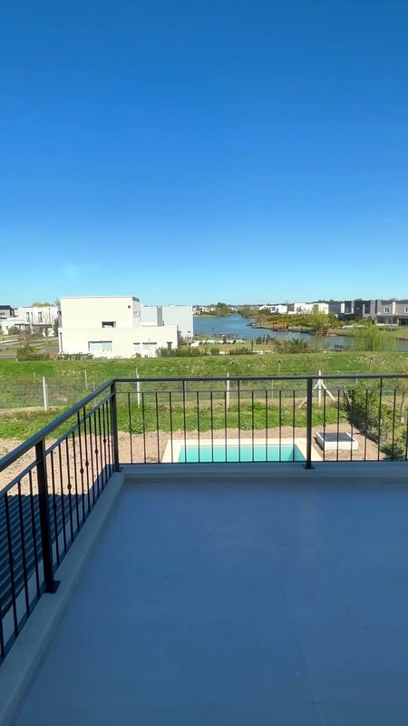 Balcón con vista al lago y la pileta — casa en venta de Estudio Aranoa